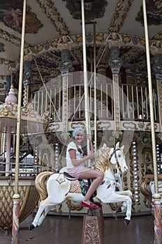 Ten-year girl riding a classic French carousel. Ð”ÐµÑÑÑ‚Ð¸Ð»